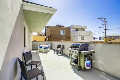 a patio with chairs and a grill on a balcony at Beachy Keen 1 in San Diego