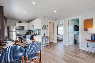 a kitchen and living room with a table and chairs at Beachy Keen 2 in San Diego