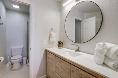 a bathroom with a sink and a mirror and a toilet at Local Gem 2 in San Diego