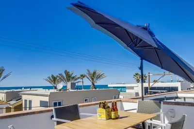 a table with bottles of wine and an umbrella at Ocean Style in San Diego