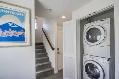 a laundry room with a washing machine and a staircase at Ocean Style in San Diego