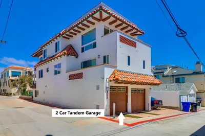 a white building with a garage on a street at Ocean Style in San Diego