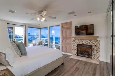a bedroom with a fireplace and a tv and a bed at Pacific Shores in San Diego
