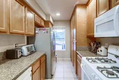 a kitchen with a stove and a white refrigerator at Palms Paradise 2 in San Diego