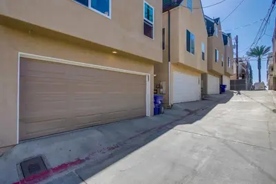 a building with two garage doors next to a driveway at Palms Paradise 2 in San Diego