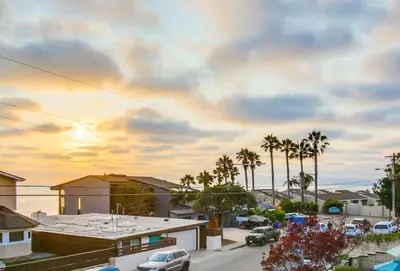 a city street with palm trees and a cloudy sky at GrandView in Encinitas