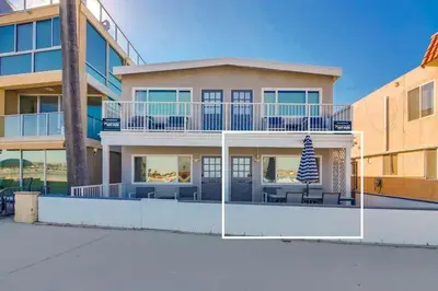 a large house with a balcony and chairs in front of it at Bayside 2 in San Diego
