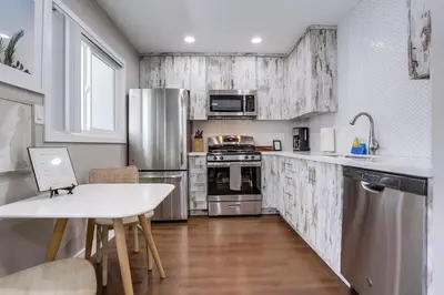 a kitchen with stainless steel appliances and a table at Bayside Bikini 1 in San Diego