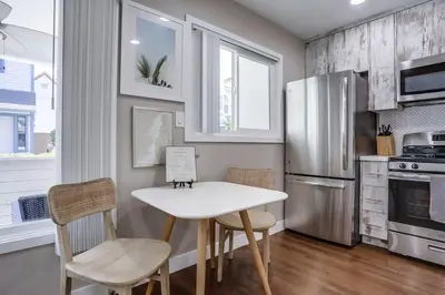 a kitchen with a table and chairs and a refrigerator at Bayside Bikini 1 in San Diego