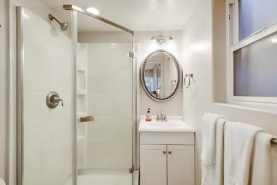 a bathroom with a shower and a sink and a mirror at Bay View in San Diego