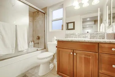a bathroom with a toilet and a tub and a sink at Bay View in San Diego