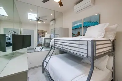 a white bedroom with a bed and a mirror at Surf Style 3 in San Diego