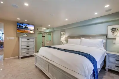 a bedroom with a large bed with a tv on the wall at Residence Club 3 in San Diego