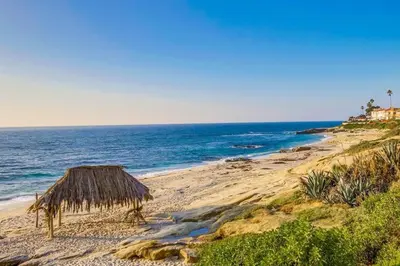 a beach with a straw hut and the ocean at Windansea 1 in San Diego