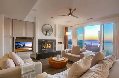 a living room with white furniture and a fireplace at Surf House in Encinitas