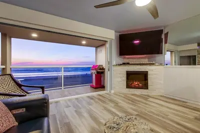 a living room with a fireplace and a view of the ocean at Beachside 4 in San Diego