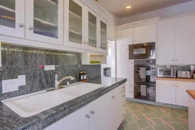 a kitchen with white cabinets and a sink at Treasure Villa in San Diego