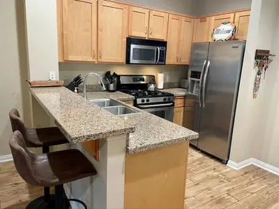 a kitchen with a stainless steel refrigerator and a sink at 28 NIGHT MINIMUM in the Gaslamp Quarter by Petco Park, pool, jacuzzi, dogs ok in San Diego