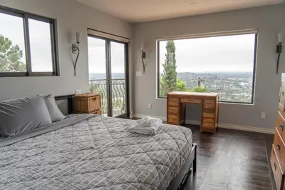 a bedroom with a bed and a desk and windows at Stunning Home & Spectacular View in La Mesa