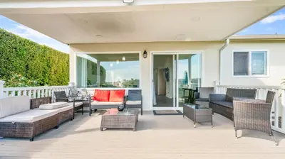 a patio with wicker furniture on a balcony at Home Ensuite with Panoramic City View in San Diego