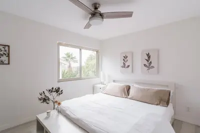 a white bedroom with a bed and a window at Spacious and Bright 5-Bedroom Oasis Pool and Yard in La Mesa
