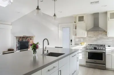 a white kitchen with a sink and a stove at Spacious and Bright 5-Bedroom Oasis Pool and Yard in La Mesa