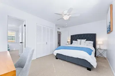 a white bedroom with a bed and a ceiling fan at Stunning BayVIEW Home with Epic Waterfront Views! in Newport Beach
