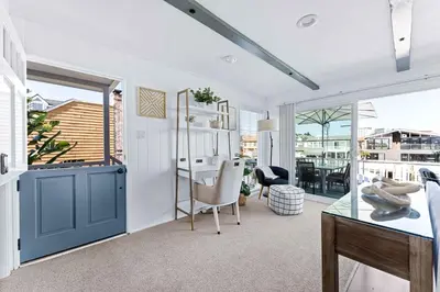 a living room with a desk and a table with a chair at Stunning BayVIEW Home with Epic Waterfront Views! in Newport Beach