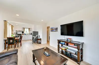 a living room with a couch and a flat screen tv at Sunny San Diego Home with Private Yard and Grill! in San Diego