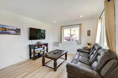 a living room with a leather couch and a table at Sunny San Diego Home with Private Yard and Grill! in San Diego