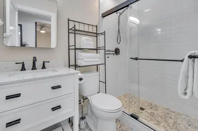 a white bathroom with a toilet and a shower at Tower 9 F in Oceanside