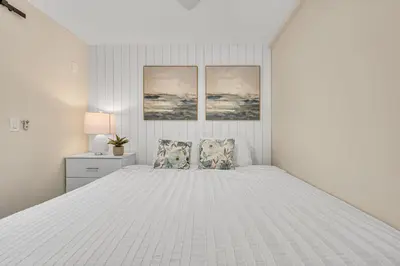 a white bedroom with a large white bed with two pillows at Tower 9 F in Oceanside