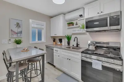 a kitchen with white cabinets and a sink and a stove at Tower 9 F in Oceanside