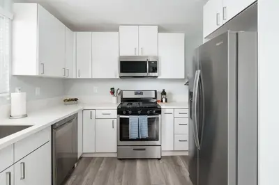 a kitchen with white cabinets and a stainless steel refrigerator at Bankers Hill Chic Roomy Home Near Airport in San Diego