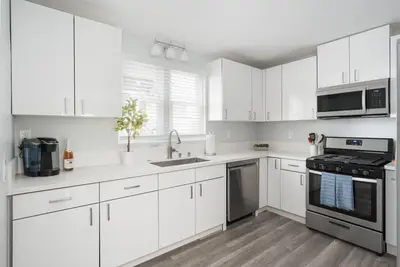 a white kitchen with white cabinets and appliances at Bankers Hill Chic Roomy Home Near Airport in San Diego