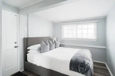a white bedroom with a large bed with a window at Bankers Hill Chic Roomy Home Near Airport in San Diego