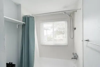 a bathroom with a shower curtain and a window at Bankers Hill Chic Roomy Home Near Airport in San Diego