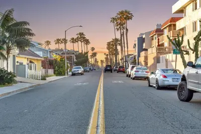 a street with cars parked on the side of a road with palm trees at Seaview 1133A in Oceanside
