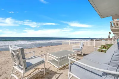 a patio with chairs and a table on the beach at Seaview 1133A in Oceanside