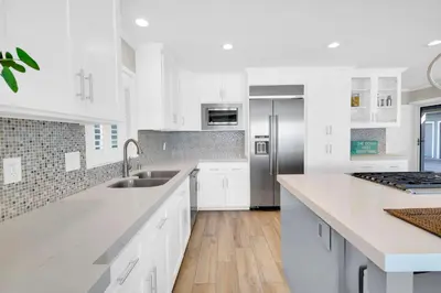 a white kitchen with a sink and a refrigerator at Seaview 1133A in Oceanside