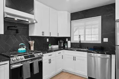a kitchen with white cabinets and a stove top oven at Safari Vines Retreat in Escondido