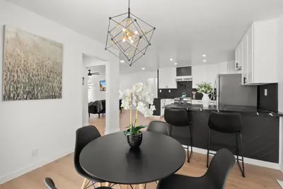 a kitchen and dining room with a black table and chairs at Safari Vines Retreat in Escondido