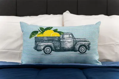 a pillow with a truck with oranges on it at Safari Vines Retreat in Escondido