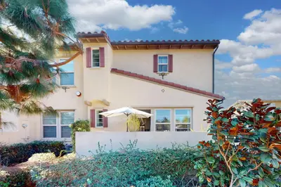 a large white house with an umbrella in front of it at Leucadia Stonesteps Retreat in Encinitas