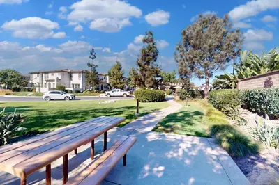 a wooden bench sitting on a sidewalk in a park at Leucadia Stonesteps Retreat in Encinitas