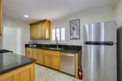 a kitchen with a stainless steel refrigerator and wooden cabinets at Centrally Located Retreat 5 Mi to San Diego Zoo! in San Diego