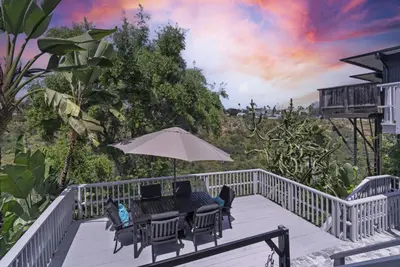 a deck with a table and chairs and an umbrella at Near All Things SD - Canyonview - Jacuzzi - EV Charge in San Diego