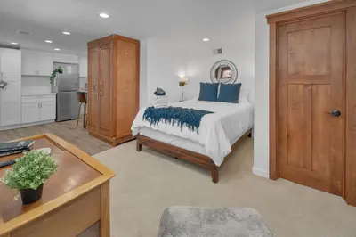 a bedroom with a bed with blue pillows on it at Near All Things SD - Canyonview - Jacuzzi - EV Charge in San Diego