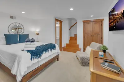 a bedroom with a bed and a tv and a chair at Near All Things SD - Canyonview - Jacuzzi - EV Charge in San Diego