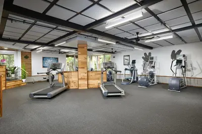 a gym with several treadmills and elliptical machines at Oceanside Beach Condos in Oceanside